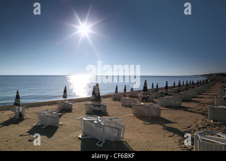 Sdraio e ombrelloni sono costruiti sulla spiaggia di mattina all'alba Foto Stock