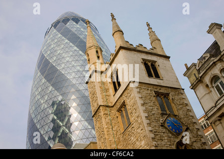 Una vista dell'edificio Gherkin e St Mary Axe chiesa della città di Londra. Foto Stock