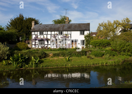 Graticcio casa sulle sponde del fiume freccia in Eardisland. Foto Stock