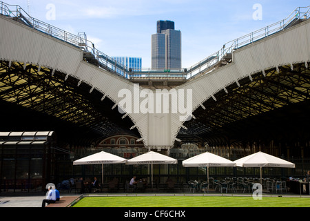 Una fila di cafe tabelle sotto grandi ombrelloni in Broadgate sul retro della stazione di Liverpool Street. Foto Stock