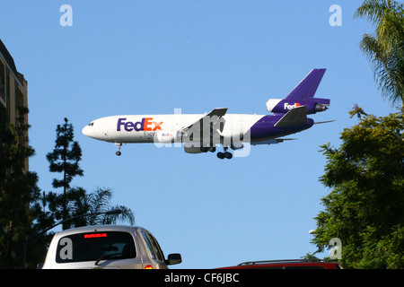 Fedex aereo in arrivo per un atterraggio su di una grande città. Foto Stock