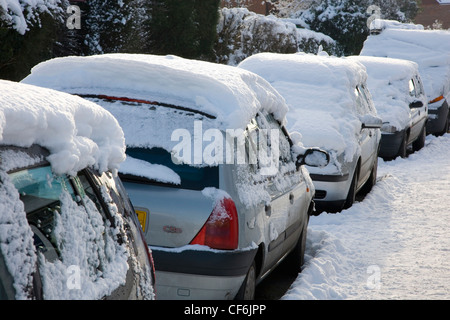 Dormansland, Surrey, Inghilterra. Linea di automobili parcheggiate coperto di neve spessa dopo una bufera di neve. Foto Stock