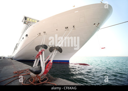 Bianco grande nave da crociera in piedi nel dock, ormeggio con funi Foto Stock