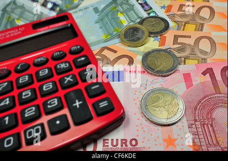 Immagine concettuale con le banconote e le monete metalliche in euro e valuta la calcolatrice per illustrare la crisi del settore bancario nei paesi dell Unione Europea Foto Stock