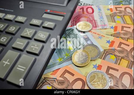 Immagine concettuale con le banconote e le monete metalliche in euro e valuta la calcolatrice per illustrare la crisi del settore bancario nei paesi dell Unione Europea Foto Stock