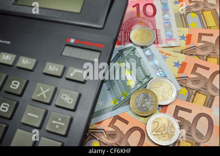 Immagine concettuale con le banconote e le monete metalliche in euro e valuta la calcolatrice per illustrare la crisi del settore bancario nei paesi dell Unione Europea Foto Stock