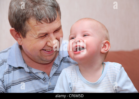 Ritratto di ridere, felice vecchio uomo e sua nipote, concentrarsi sul bambino più piccolo dente Foto Stock