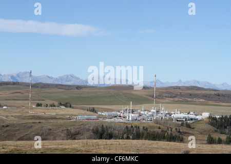 Il gas naturale nello stabilimento di trasformazione vicino nelle montagne rocciose canadesi con le montagne rocciose visibile all'orizzonte. Foto Stock