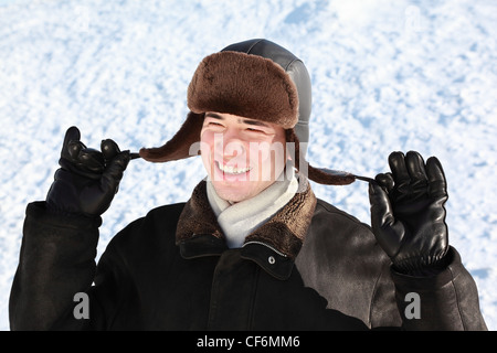 Ragazzo mantiene sul orecchio cordages-flaps hat Foto Stock