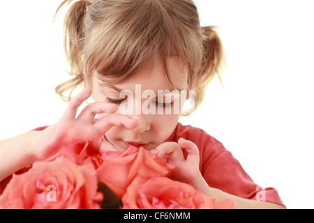 Ragazza esamina attentamente e tocca i petali di rose Foto Stock