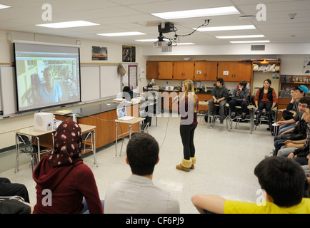 Classe di studenti americani in una videoconferenza con un ricercatore presso una stazione di campo in Panama- ragazza con mic domande Foto Stock