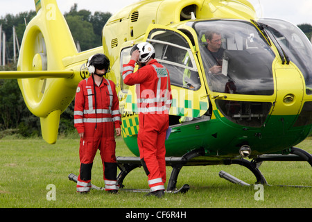 Essex Air Ambulance equipaggio effettuare pre volo controlli sul loro Eurocopter EC-135 aeromobili. Foto Stock