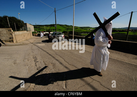 Uomo che porta una croce per il "Lunissanti" la settimana santa celebrazione, Castelsardo, Italia Foto Stock