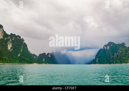 Condizioni climatiche avverse in Khao Sok National Park, Thailandia. Un avvicinamento temporale è chiaramente visibile in distanza. Foto Stock