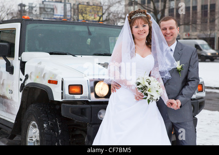 Sposa e lo sposo in piedi accanto a AUTO limousine in stagione invernale Foto Stock