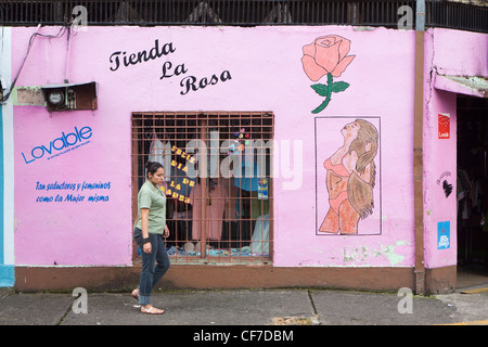 Una donna cammina passato un colorato dipinto il negozio nella città di Turrialba Costa Rica Foto Stock