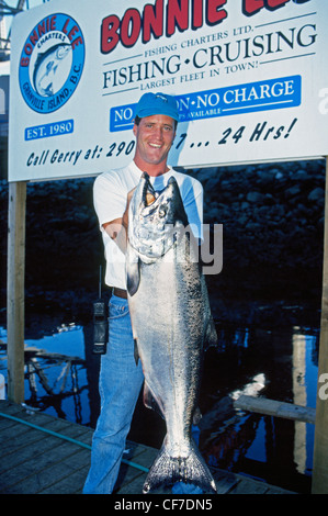 Un felice pescatore mostra con orgoglio il grande Salmone Chinook ha catturato mentre su una barca di pesca sportiva operando da Vancouver, British Columbia, Canada. Foto Stock