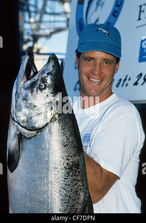 Un felice pescatore mostra con orgoglio il grande Salmone Chinook ha catturato mentre su una barca di pesca sportiva operando da Vancouver, British Columbia, Canada. Foto Stock