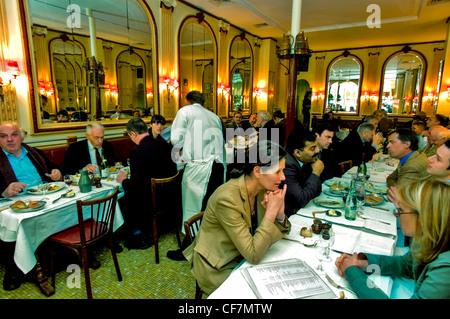 PARIGI, Francia, - adulti che condividono i pasti nella sala da pranzo del tradizionale ristorante bistrot francese. Pranzo d'affari al 'Chez Georges', interni, luci da pranzo per donne, bistrot gastronomico francese, pranzo per uomini d'affari Foto Stock