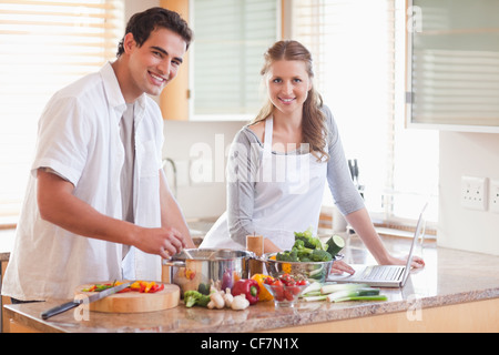 Paio utilizzando notebook per cercare la ricetta Foto Stock