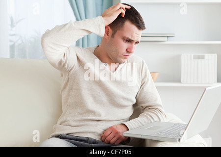 Confuso uomo che utilizza un notebook Foto Stock