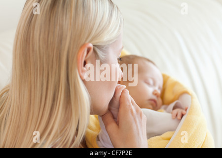 Al di sopra di vista della madre baciare il suo bambino la mano Foto Stock
