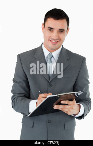 Imprenditore sorridente prendendo appunti Foto Stock