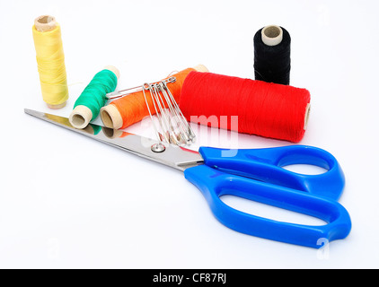 Forbici blu e i vari fili colorati. Foto Stock