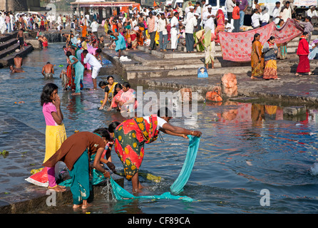 Le donne lavare i loro sari. Fiume Godavari. Nasik. India Foto Stock