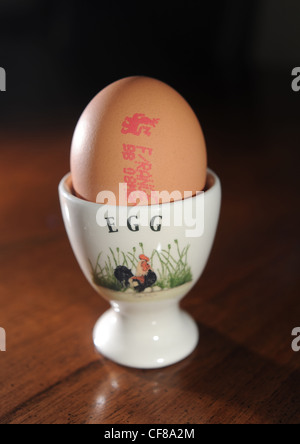 Free Range egg con controllo di qualità marchio apposto sul guscio in un eggcup . Il prezzo della scelta libera di uova è impostato a salire REGNO UNITO Foto Stock