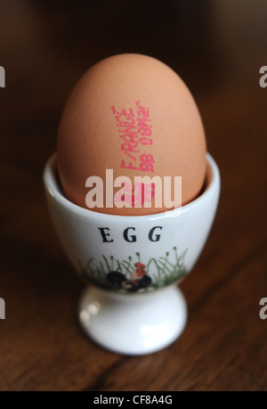 Free Range egg con controllo di qualità marchio apposto sul guscio in un eggcup . Il prezzo della scelta libera di uova è impostato a salire REGNO UNITO Foto Stock