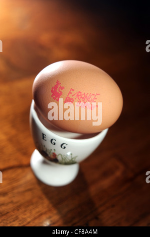 Free Range egg con controllo di qualità marchio apposto sul guscio in un eggcup . Il prezzo della scelta libera di uova è impostato a salire REGNO UNITO Foto Stock