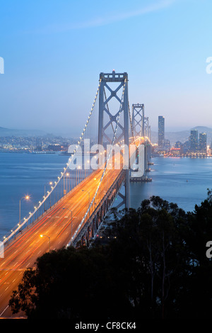 Stati Uniti, California, San Francisco, Oakland Bay Bridge al tramonto e dello skyline della città Foto Stock