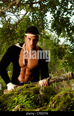 Vista di un combattente maschio tiene in mano una mazza arma su una foresta. Foto Stock