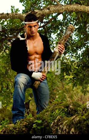 Vista di un combattente maschio tiene in mano una mazza arma su una foresta. Foto Stock