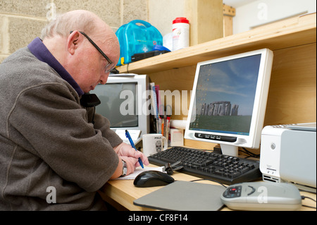 Un maschio di disabili con più di malformazioni congenite lavorando sulla linea telefonica di assistenza presso la sede di disabilità Essex. Foto Stock