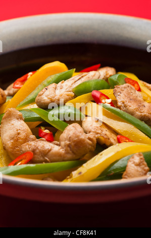 Pollo fritto con peperoni rossi sulla tovaglia riprese in studio Foto Stock