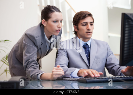 Il team di Business guardando lo schermo del computer insieme Foto Stock