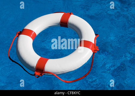 Un pneumatico di emergenza flottante in una piscina. icona foto per gli aiuti, il debito e il fallimento Foto Stock