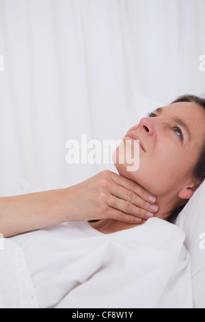 Sfregamento della donna sua gola Foto Stock