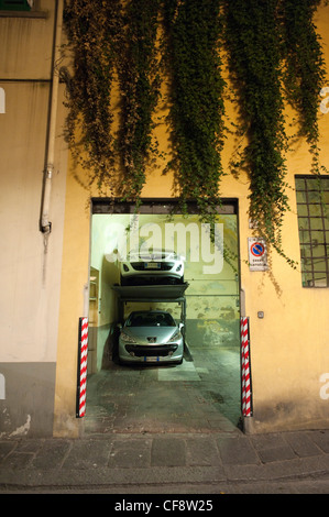 Parco auto di sollevamento raccoglitore di un sistema in un vecchio garage in Florecne Foto Stock