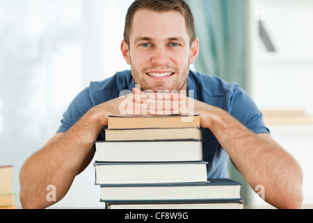 Studente sorridente appoggiato sui suoi libri Foto Stock