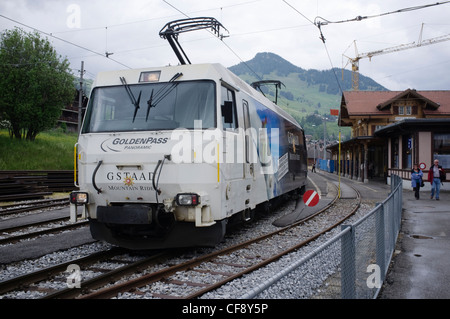 Goldenpass Panoramic express passando Montbovon stazione. Montreux-Oberland Bernois railway uno dei più antichi delle ferrovie elettriche in Foto Stock