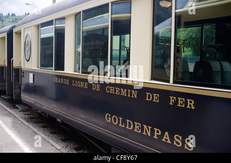 Goldenpass Panoramic express passando Montbovon stazione. Montreux-Oberland Bernois railway uno dei più antichi delle ferrovie elettriche in Foto Stock