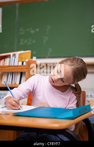 Ritratto di un concentrato schoolgirl iscritto Foto Stock
