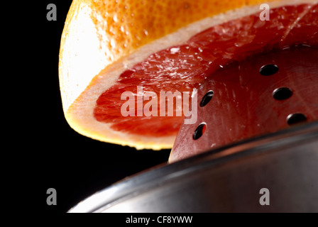 Succo di pompelmo fresco in procinto di essere juiced per la prima colazione Foto Stock