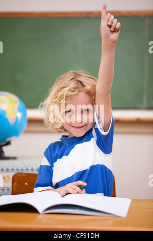 Ritratto di uno scolaro alzando la mano Foto Stock