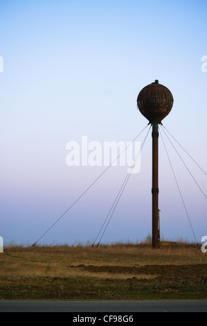 Vecchio arrugginito water tower di sera Foto Stock