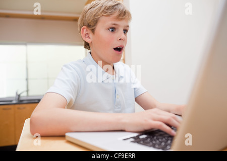 Ragazzo sorpreso con un notebook Foto Stock