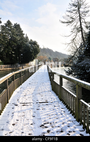 L uomo e la donna si cammina su strade coperte di neve passerella sul fiume Tamigi, a bloccaggio di palude, Henley-on-Thames, Berkshire, Inghilterra, Foto Stock
